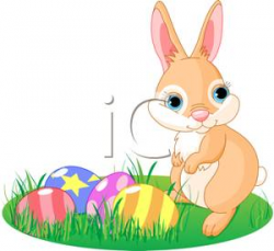 Cute Bunny Standing In the Grass Over a Group of Colored Eggs ...