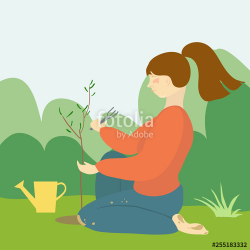 Young woman sitting on grass with the watering can planting ...